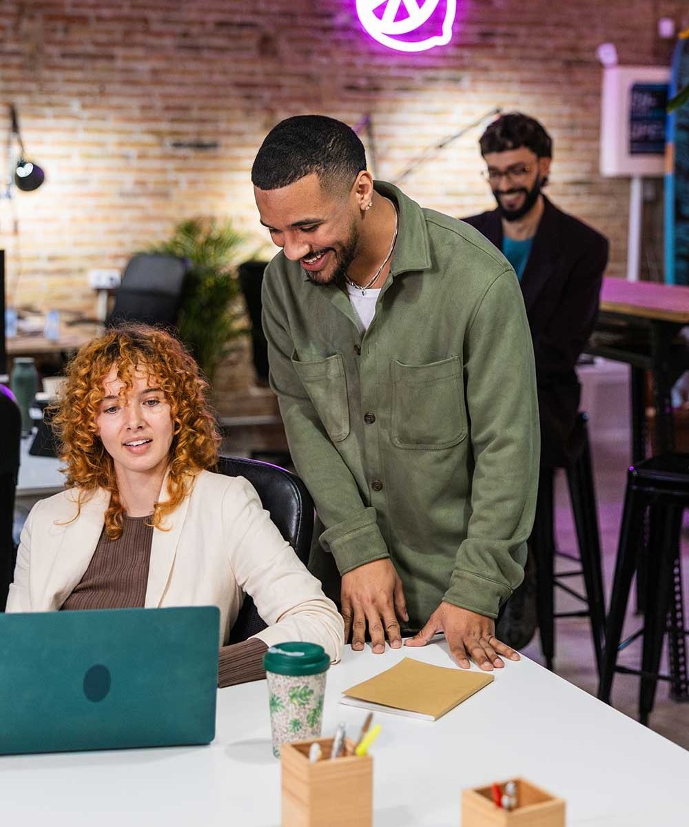 multi-ethnic-team-collaborating-on-laptop-in-moder-RTPC8ZL